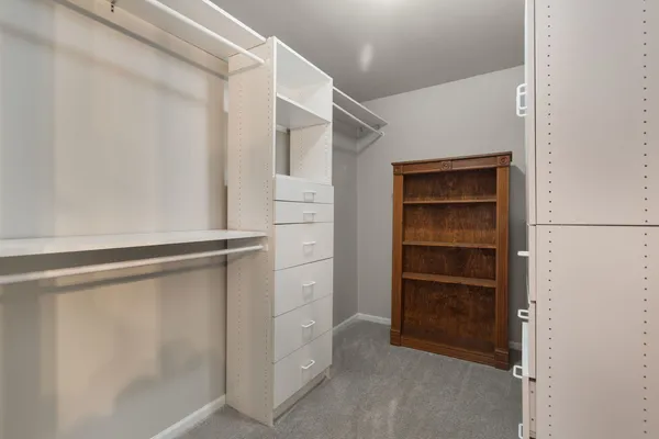 a view of walk in closet with empty racks