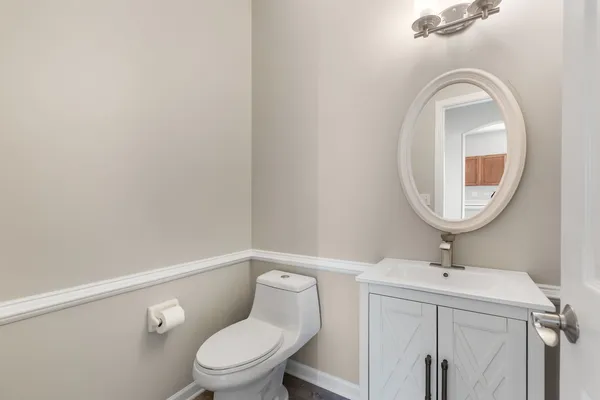 a bathroom with a toilet a sink and mirror