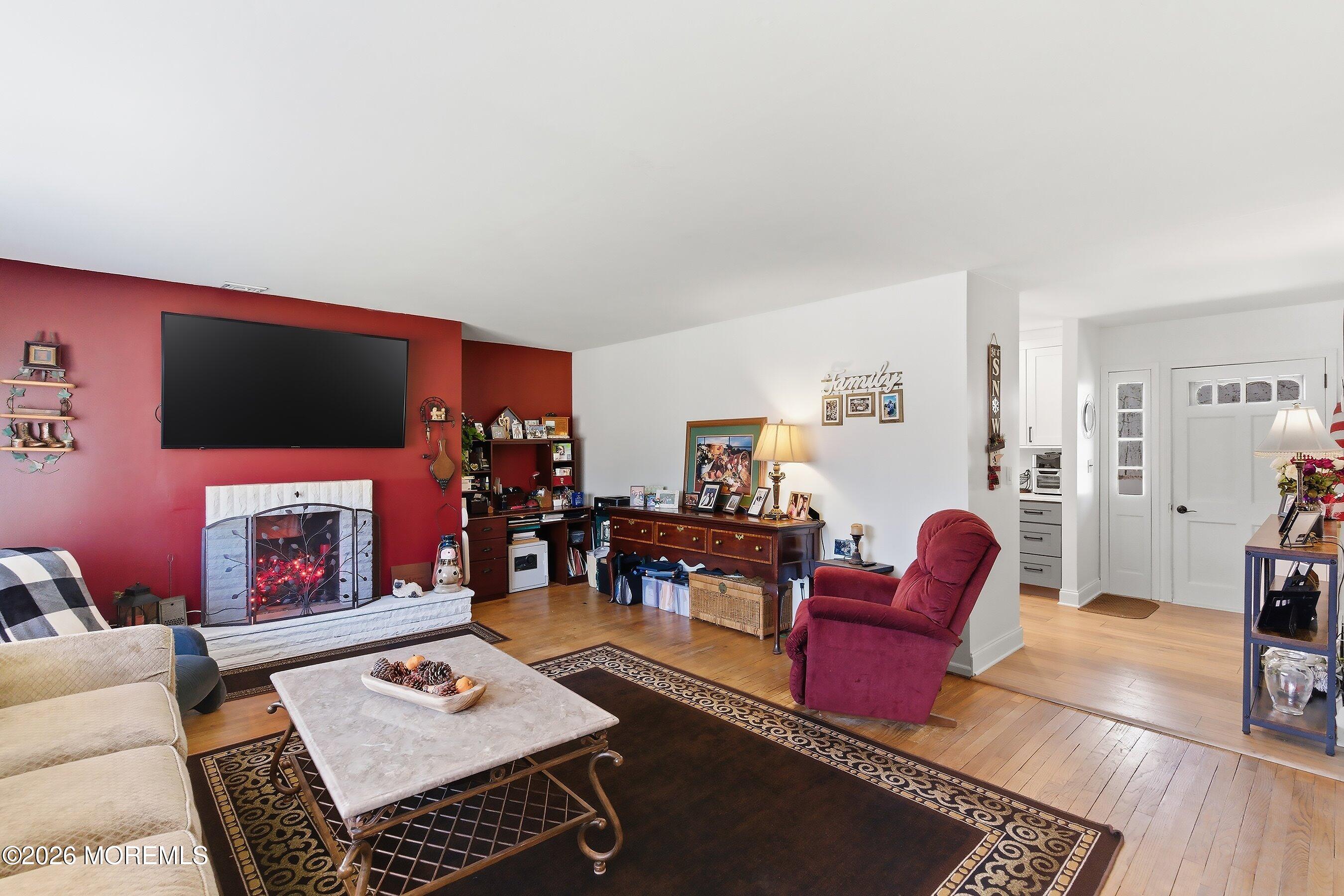 745 Oak Glen Road Howell, NJ 07731 - Photo 9 of 46 a living room with furniture a flat screen tv and a fireplace