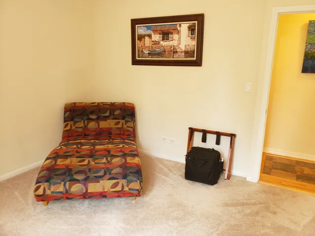 a bedroom with a bed and a painting on the wall