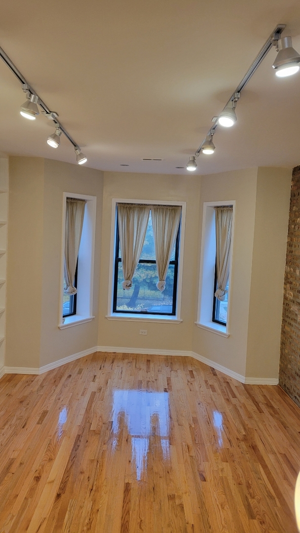 5946 South Prairie Avenue, Unit 2S Chicago, IL 60637 - Photo 4 of 18 a view of an empty room with wooden floor and window