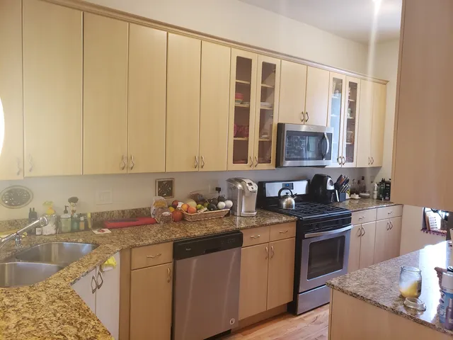 a kitchen with stainless steel appliances granite countertop a sink stove and cabinets