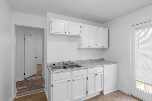 a kitchen with stainless steel appliances granite countertop white cabinets and sink