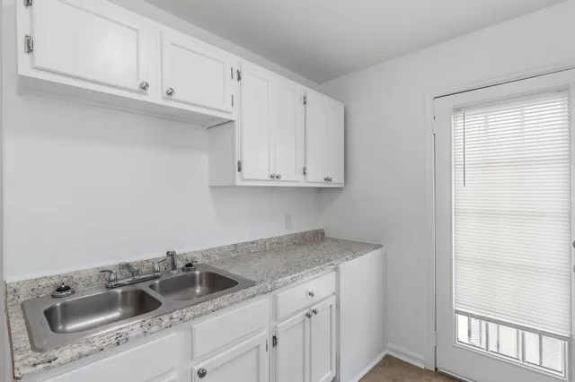 a kitchen with white cabinets sink and dishwasher