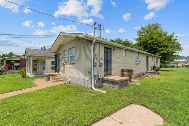 a view of a house with a yard and sitting area