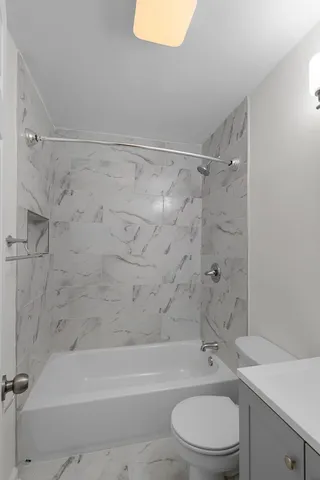 a bathroom with a toilet sink vanity and bathtub