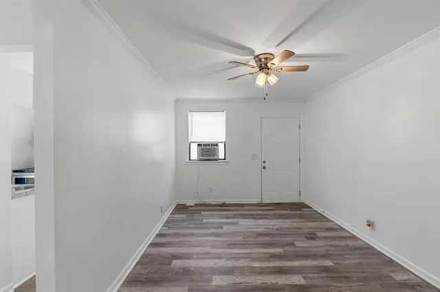 a view of a workspace with wooden floor and a chandelier fan