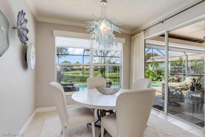 9871 Rookery Circle Estero, FL 33928 - Photo 15 of 38 a view of a dining room with furniture large windows and wooden floor