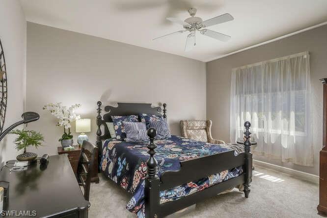 9871 Rookery Circle Estero, FL 33928 - Photo 20 of 38 a bed room with a bed and a chandelier