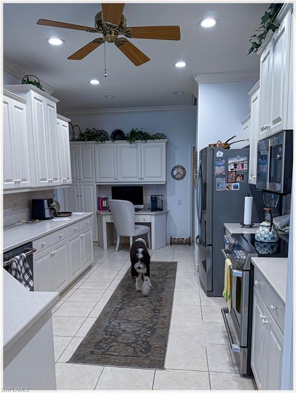 9871 Rookery Circle Estero, FL 33928 - Photo 10 of 33 a kitchen with stainless steel appliances kitchen island granite countertop a refrigerator oven a sink a dining table and chairs with wooden floor