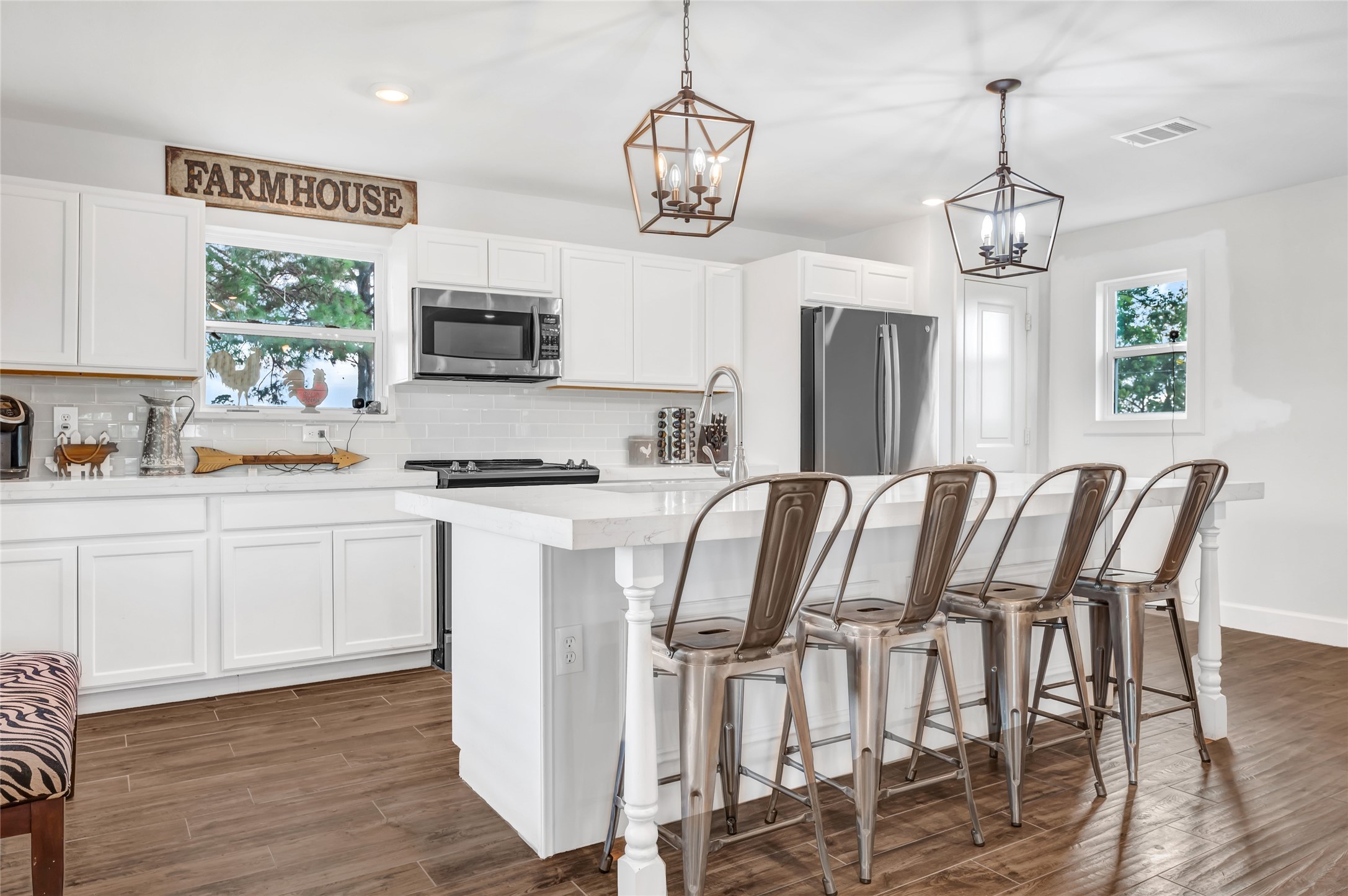 868 Lisa May Road Bellville, TX 77418 - Photo 22 of 39 a kitchen with stainless steel appliances granite countertop a stove top oven a refrigerator a sink a dining table and chairs with wooden floor