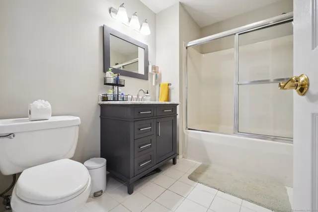 a bathroom with a toilet sink vanity and mirror