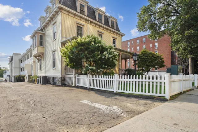 a view of a house with a small yard and wooden fence