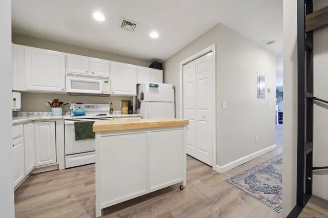 a kitchen with cabinets and wooden floor