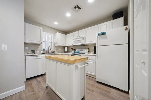 a kitchen with white cabinets and white stainless steel appliances