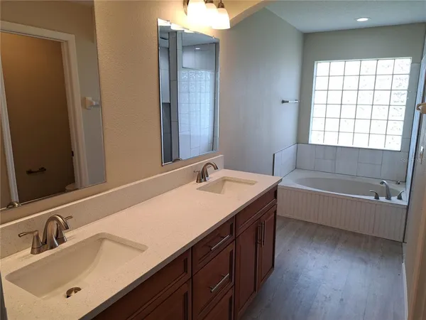 a bathroom with a tub sink and mirror