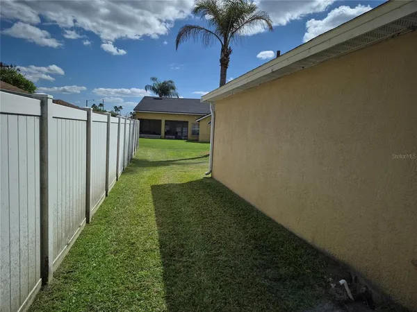 a view of a yard with wooden fence