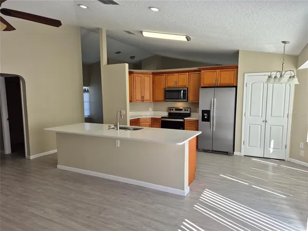 a kitchen with stainless steel appliances a refrigerator and a stove top oven
