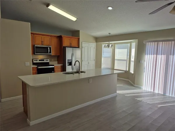 a kitchen with stainless steel appliances a sink a stove a refrigerator and cabinets