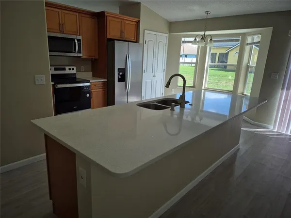 a kitchen with stainless steel appliances granite countertop a sink a stove and a refrigerator