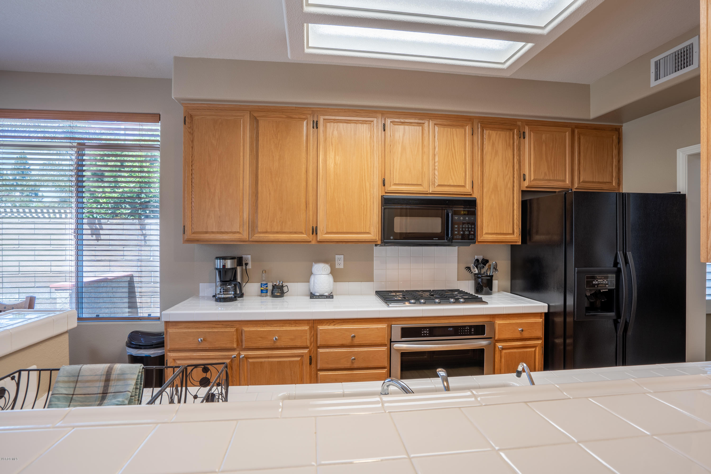 3931 Sunsetridge Road Moorpark, CA 93021 - Photo 14 of 36 a kitchen with stainless steel appliances kitchen island granite countertop a refrigerator and a stove top oven