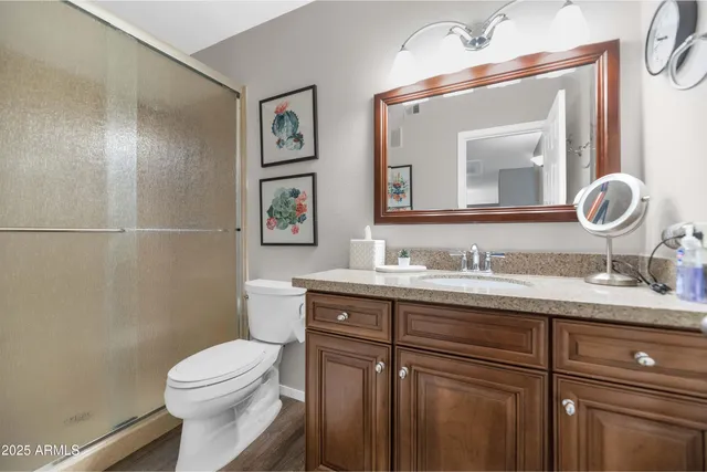 a bathroom with a granite countertop toilet sink and mirror