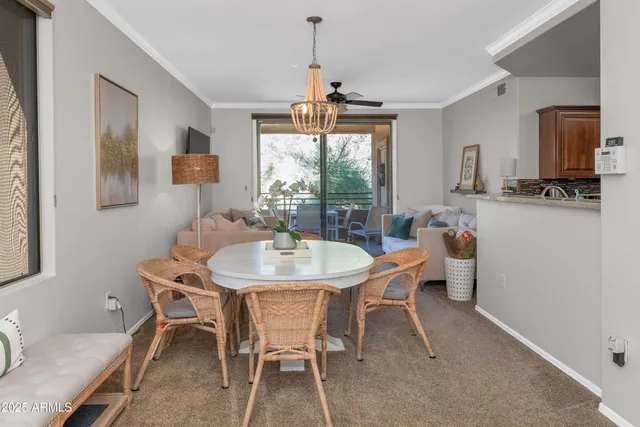 a dining room with furniture a chandelier and window