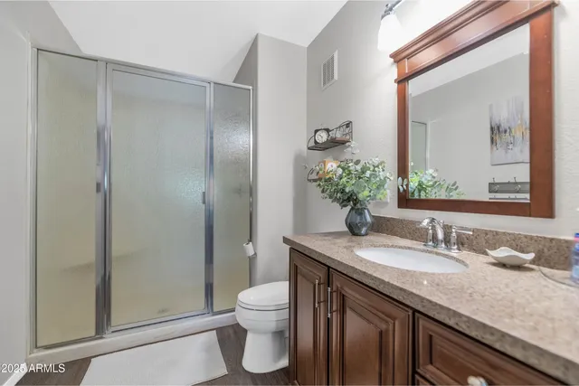 a bathroom with a granite countertop sink toilet and shower