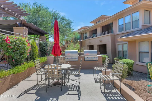 a view of a patio with a dining table and chairs with wooden floor and plants