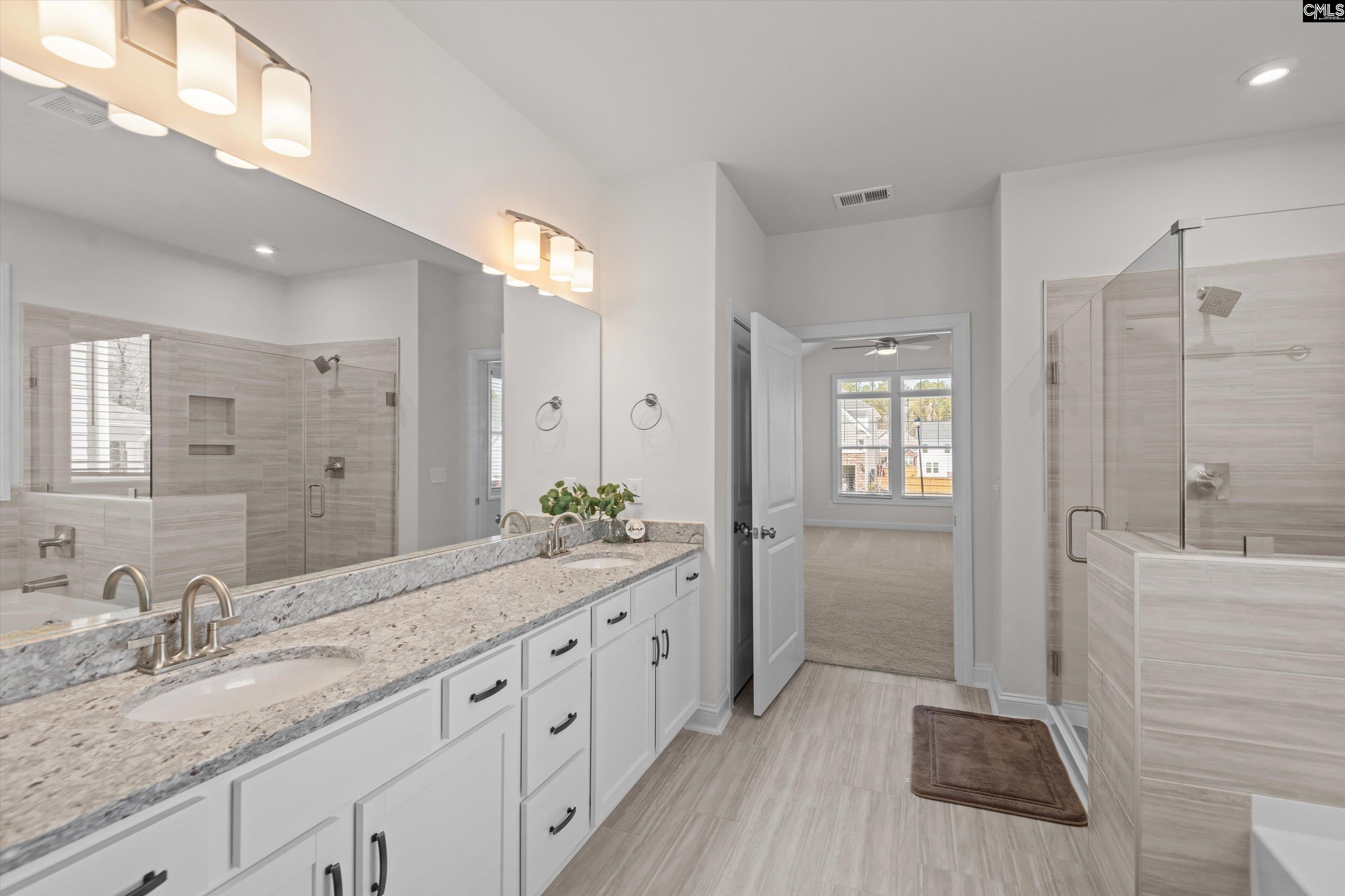 558 Wild Ginger Loop Irmo, SC 29063 - Photo 25 of 42 a spacious bathroom with a granite countertop sink a mirror and a shower