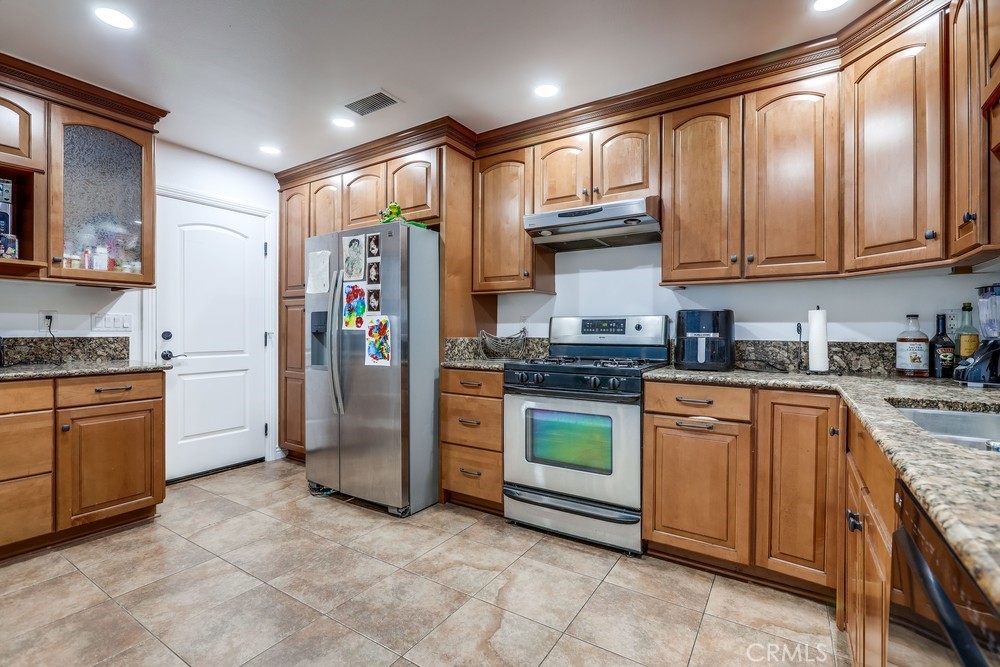 9678 Walker Court Cypress, CA 90630 - Photo 12 of 40 a kitchen with stainless steel appliances granite countertop a refrigerator stove and sink