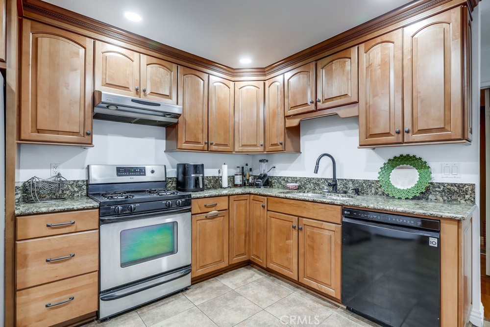 9678 Walker Court Cypress, CA 90630 - Photo 14 of 40 a kitchen with stainless steel appliances granite countertop a stove sink and cabinets