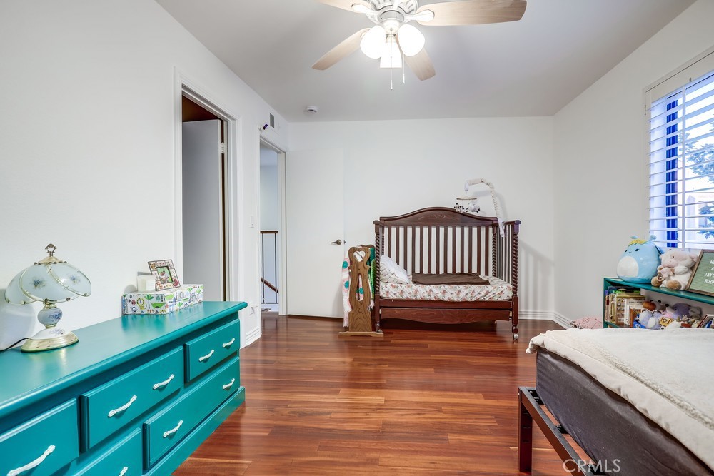 9678 Walker Court Cypress, CA 90630 - Photo 21 of 40 a spacious bedroom with a bed and a chandelier