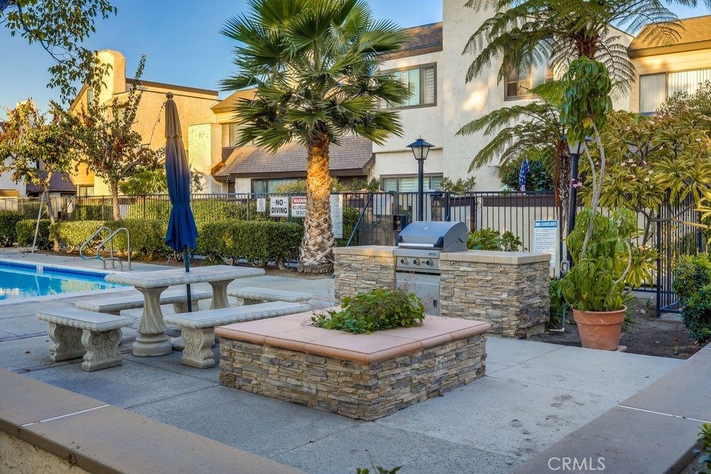 9678 Walker Court Cypress, CA 90630 - Photo 38 of 40 a view of a patio with table and chairs potted plants and palm tree