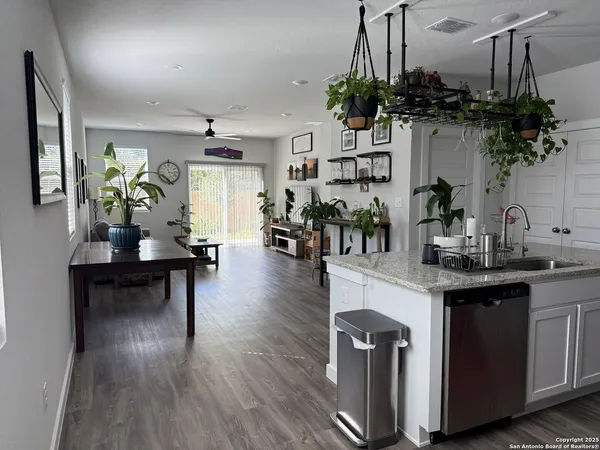 a living room with furniture a chandelier a potted plant and a large window