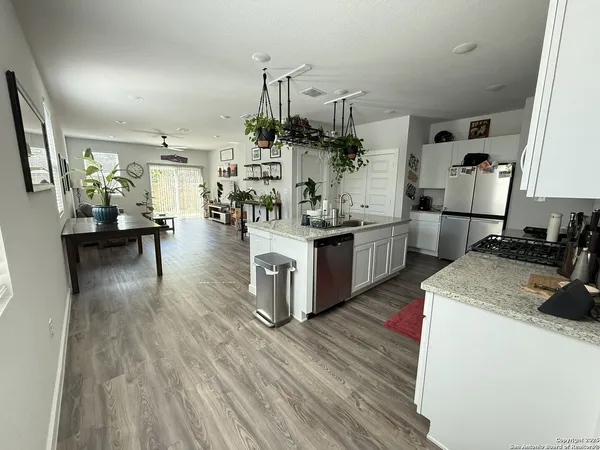 a kitchen with stainless steel appliances granite countertop wooden floors and sink
