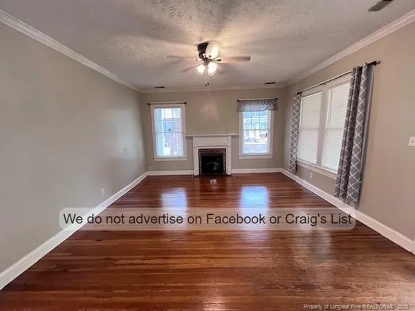 a view of empty room with wooden floor and fireplace