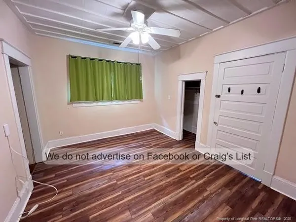 a view of a bedroom with wooden floor and windows