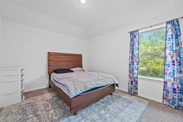 a bedroom with a bed and a window