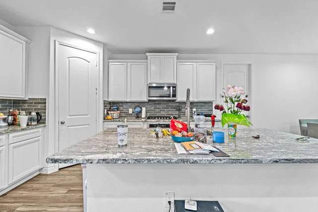a kitchen with stainless steel appliances granite countertop a sink stove and cabinets