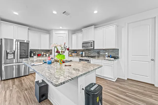 a kitchen with stainless steel appliances granite countertop a sink refrigerator and microwave