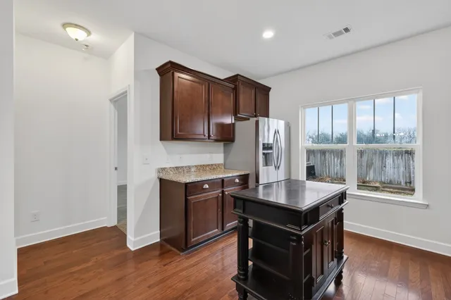 a kitchen with kitchen island a counter top space appliances and a window