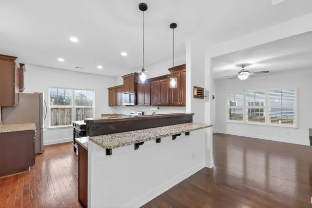 a large kitchen with kitchen island a large counter top space a sink stainless steel appliances and cabinets