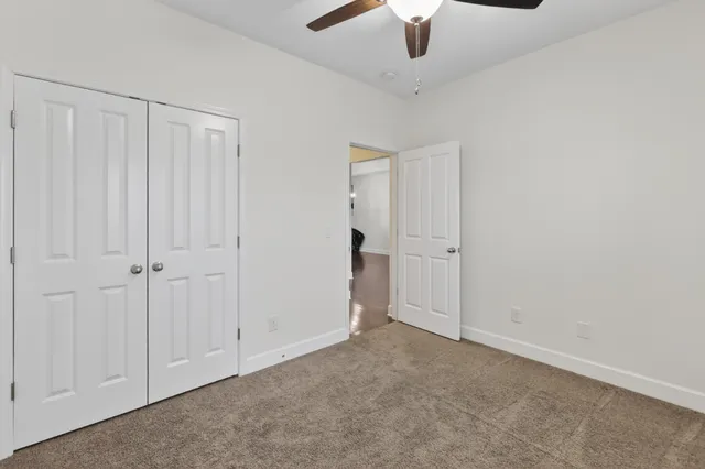 an empty room with chandelier fan