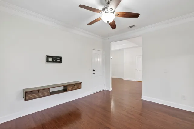 a view of an empty room with wooden floor