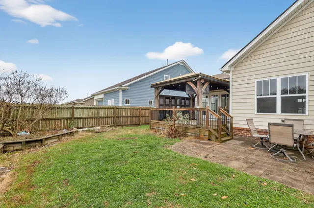 a view of backyard with table and chairs
