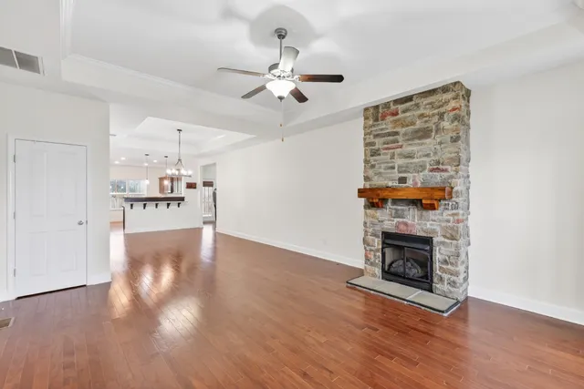 a view of empty room with wooden floor and fireplace