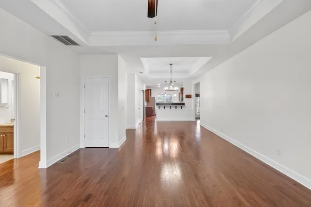 a view of a room with wooden floors and ceiling fan