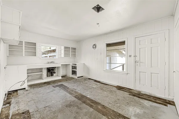 an empty room with fireplace and windows