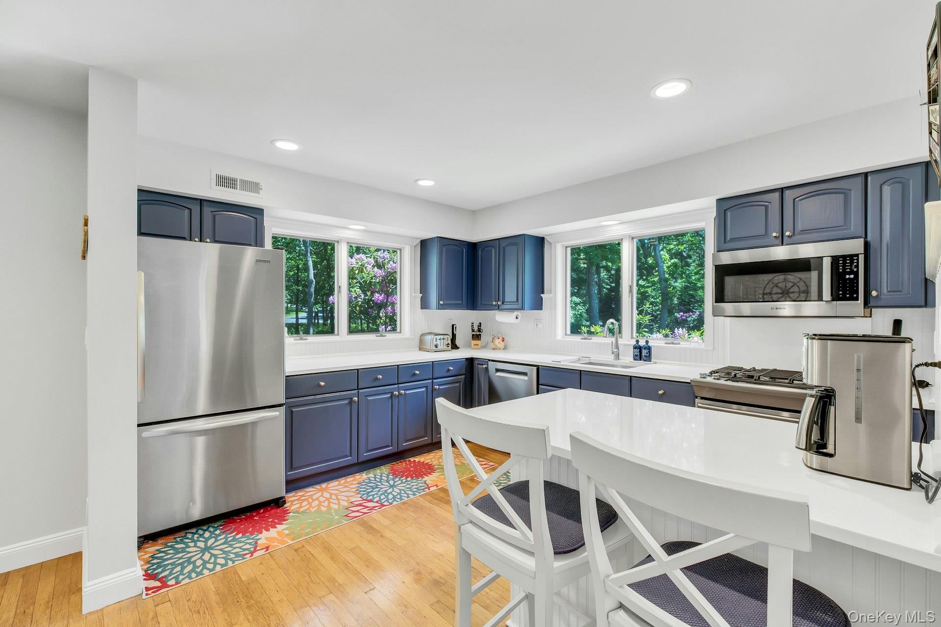 16 Hildreth Road Hampton Bays, NY 11946 - Photo 10 of 29 a kitchen with stainless steel appliances granite countertop a refrigerator a stove top oven a sink dishwasher and white cabinets with wooden floor